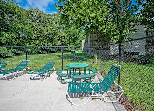 A green picnic table and chairs are set up in a fenced-in area at Sawbranch Apartments, Summerville, South Carolina