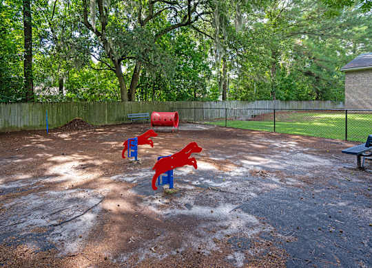 A playground with red and blue slides and a green bench at Sawbranch Apartments, Summerville