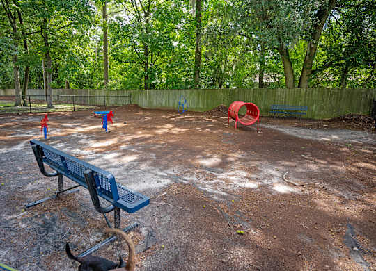 A playground with a blue bench and a red tunnel at Sawbranch Apartments, Summerville, South Carolina