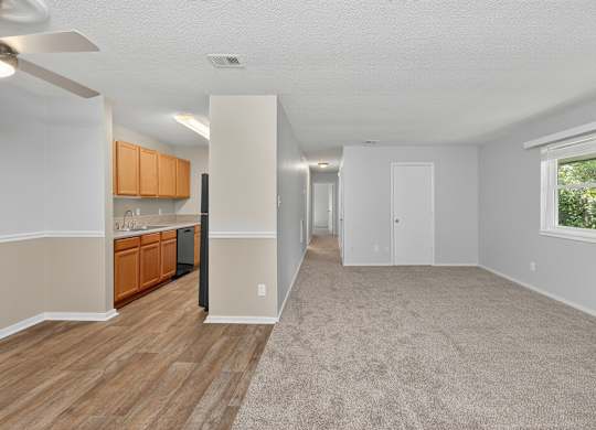 A spacious room with wooden flooring and a carpeted area at Sawbranch Apartments, Summerville, SC, 29485