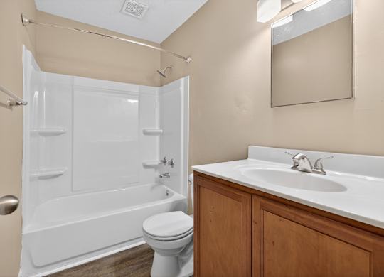 A white toilet sits next to a white sink in a bathroom at Sawbranch Apartments, South Carolina, 29485