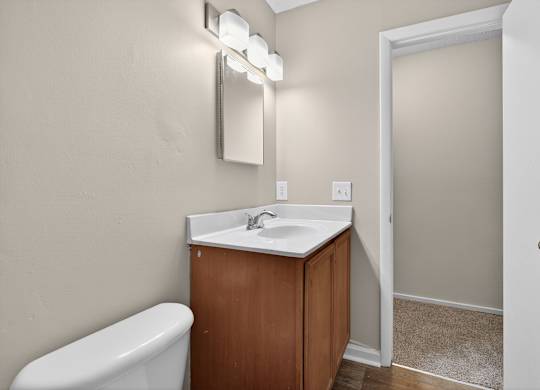 A white sink is on a wooden cabinet in a bathroom at Sawbranch Apartments, Summerville, SC, 29485