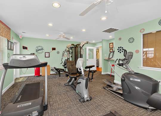 A gym with treadmills, exercise bikes, and other equipment at Woodlocke Apartments, Moncks Corner 27461