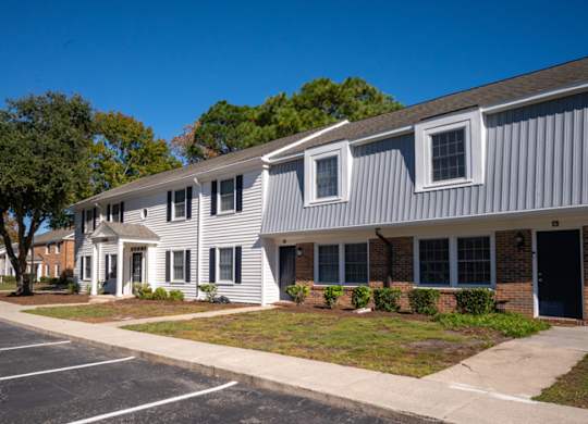 A building with a grey and white exterior is shown at The Preserve at Pine Valley Apartments, Wilmington, NC, 28412