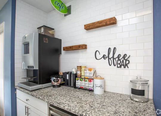 A coffee bar with a black fridge and a white counter at The Preserve at Pine Valley Apartments, Wilmington