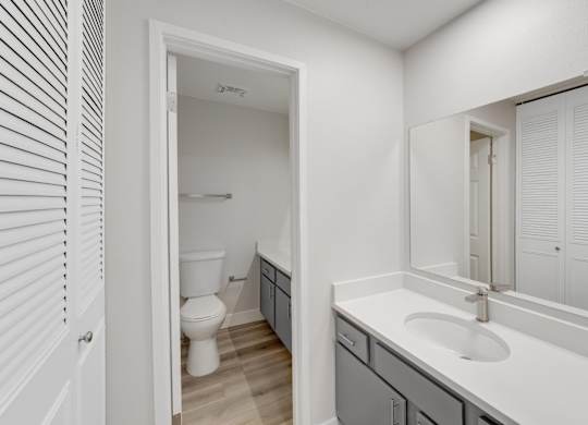 A white bathroom with a toilet and sink. at The Lex At Lowry, Denver, Colorado