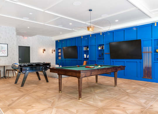 A room with a pool table and a TV.at The Vale at the Parks, Washington District of Columbia  