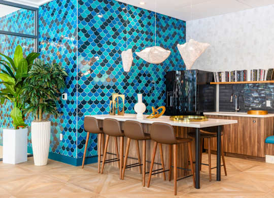 A kitchen with a blue tiled wall and wooden chairs.at The Vale at the Parks, District of Columbia, 20012