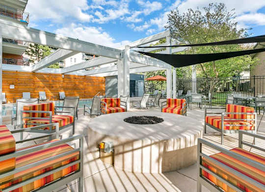 A patio with a fire pit and chairs. at The Lex At Lowry, Denver