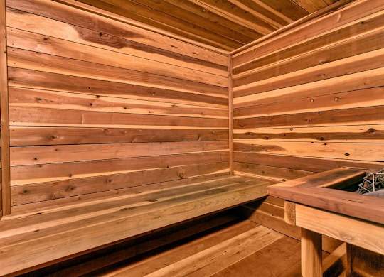 A wooden sauna with a bench and a table. at The Lex At Lowry, Denver, CO