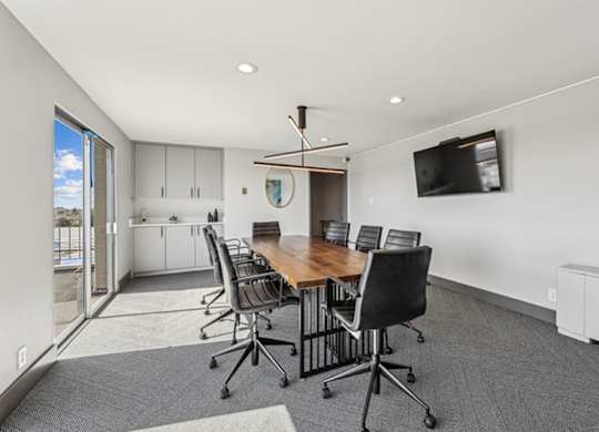 A conference room with a long table and chairs. at The Lex At Lowry, Denver, CO, 80224