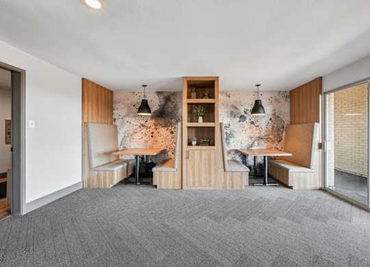 A room with a grey carpet and a wooden bookshelf. at The Lex At Lowry, Denver, 80224