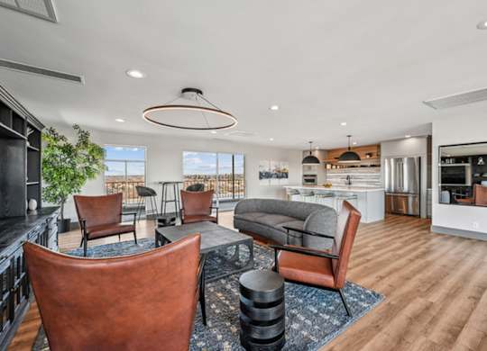 A modern living room with brown leather chairs and a wooden floor. at The Lex At Lowry, Denver, Colorado
