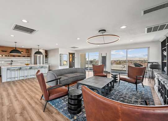 A modern living room with a grey sofa and wooden chairs. at The Lex At Lowry, Denver, Colorado