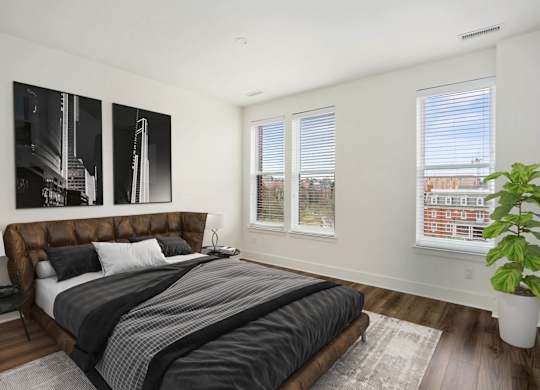 A bedroom with a large bed and a plant.at The Vale at the Parks, District of Columbia  