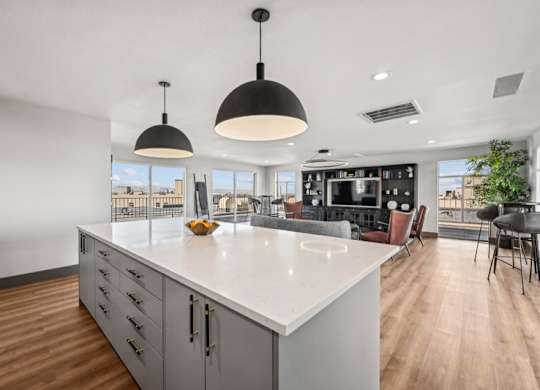 A modern kitchen with a large island and pendant lights. at The Lex At Lowry, Denver