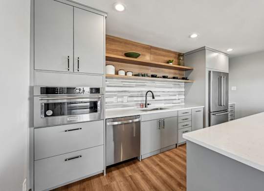 A modern kitchen with stainless steel appliances and wooden accents. at The Lex At Lowry, Denver, Colorado