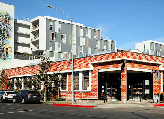 A red brick building with a white car parked in front.at Prizma, Los Angeles California  
