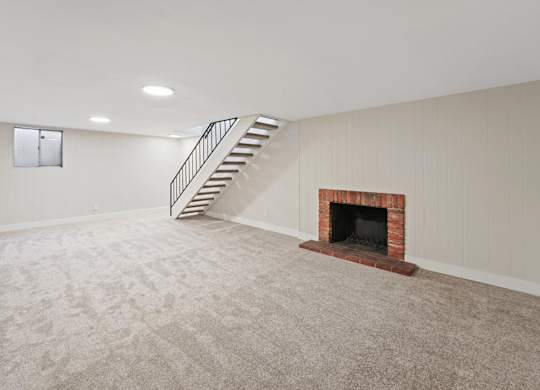 A room with a fireplace and a staircase. at The Lex At Lowry, Colorado, 80224