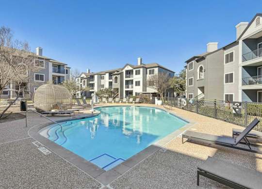A pool surrounded by apartment buildings and a sun lounger.at Onyx183, Austin  