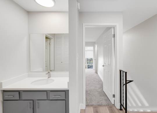 A bathroom with a sink, mirror, and cabinets. at The Lex At Lowry, Denver, CO, 80224