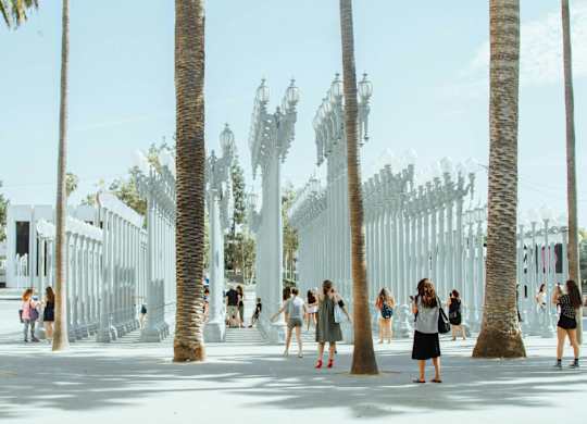 Group of people are walking through a park at 701 Hudson, Los Angeles, CA