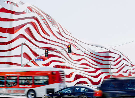  Red and white bus is driving at 701 Hudson, Los Angeles, CA, 90005