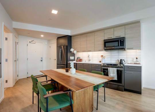 A modern kitchen with a dining table and chairs.at Channel House, Oakland, 94607