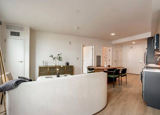 A modern living room with a white sofa and a wooden floor.at Channel House, Oakland, CA 94607