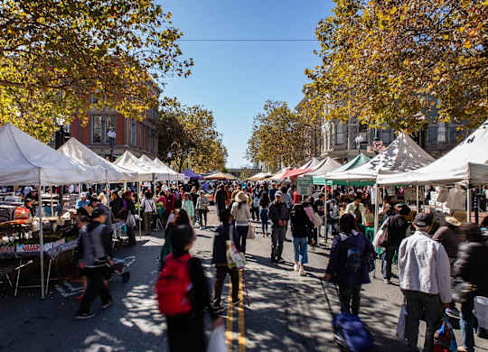 A busy street market with people walking around and shopping.at Channel House, California