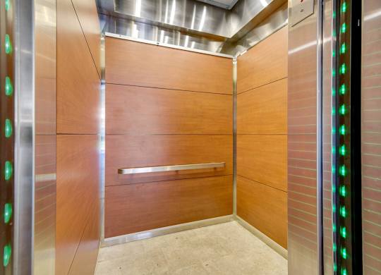 A modern elevator with green lights on the side. at The Lex At Lowry, Denver