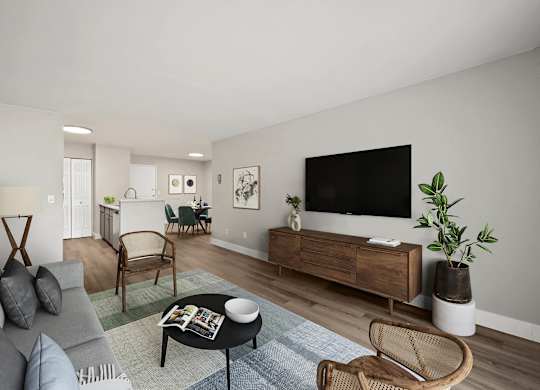 A living room with a grey couch, a black coffee table, and a flat screen TV on a wooden cabinet. at The Lex At Lowry, Denver