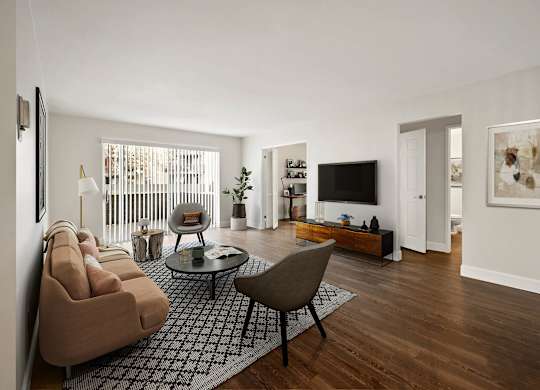A living room with a brown sofa and a glass coffee table. at The Lex At Lowry, Denver, CO