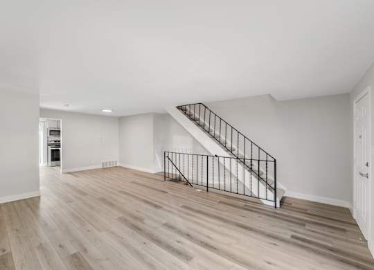 A spacious room with a staircase and wooden flooring. at The Lex At Lowry, Denver, 80224