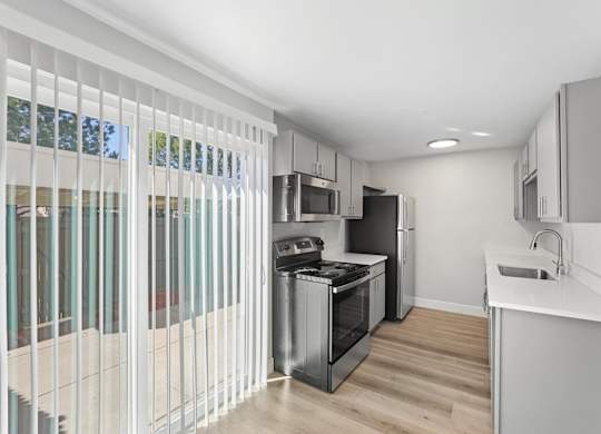 A modern kitchen with white cabinets and a stainless steel oven. at The Lex At Lowry, Denver, Colorado