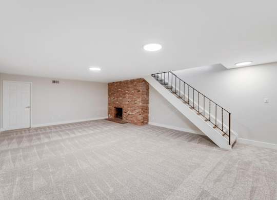 A room with a carpeted floor and a staircase leading to a loft. at The Lex At Lowry, Colorado