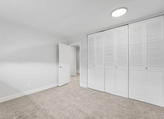 A room with white cupboards and a carpeted floor. at The Lex At Lowry, Denver, Colorado