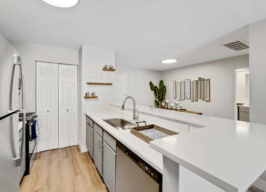 A modern kitchen with white countertops and a large island. at The Lex At Lowry, Denver, Colorado