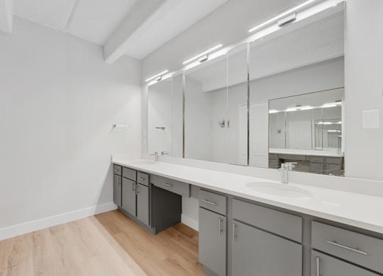 A bathroom with a sink, mirror, and cabinets. at The Lex At Lowry, Denver