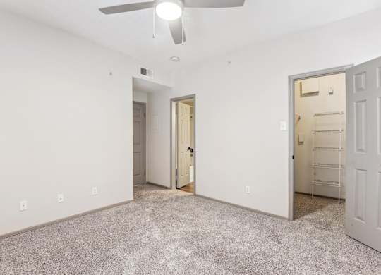A room with a ceiling fan and two doors.at Onyx183, Austin, TX  