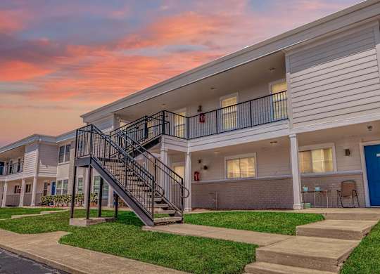 A modern apartment building with a staircase leading to the second floor.