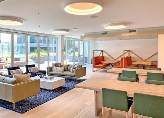 A modern living room with a sofa set, a coffee table, and a dining table.at Prizma, Los Angeles, 90038  