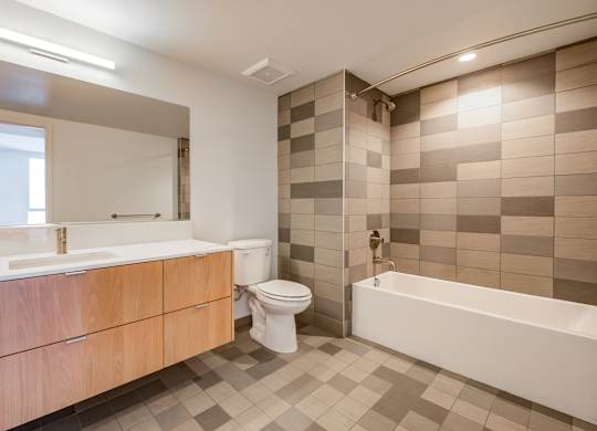 A bathroom with a white tub, sink, and toilet.at Prizma, Los Angeles  