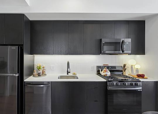 Modern kitchen with black refrigerator at Velaris Living Apartments, Colorado