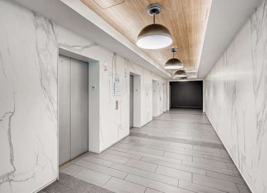 A long hallway with marble walls and a wooden ceiling.
