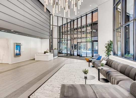 A modern art gallery with a long grey couch and a painting on the wall.
