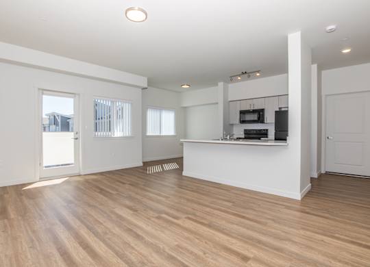 A spacious room with wooden floors and white walls.