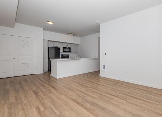 A kitchen with a white counter and wooden floors.