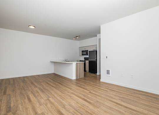 A room with a white counter and a black refrigerator.
