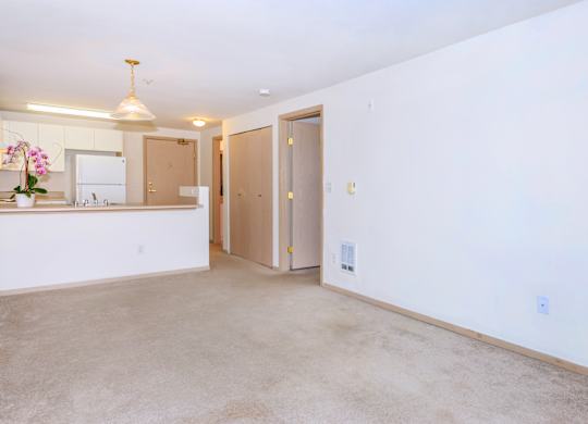 A kitchen with a sink, a refrigerator, and a counter with a vase of flowers on it.
